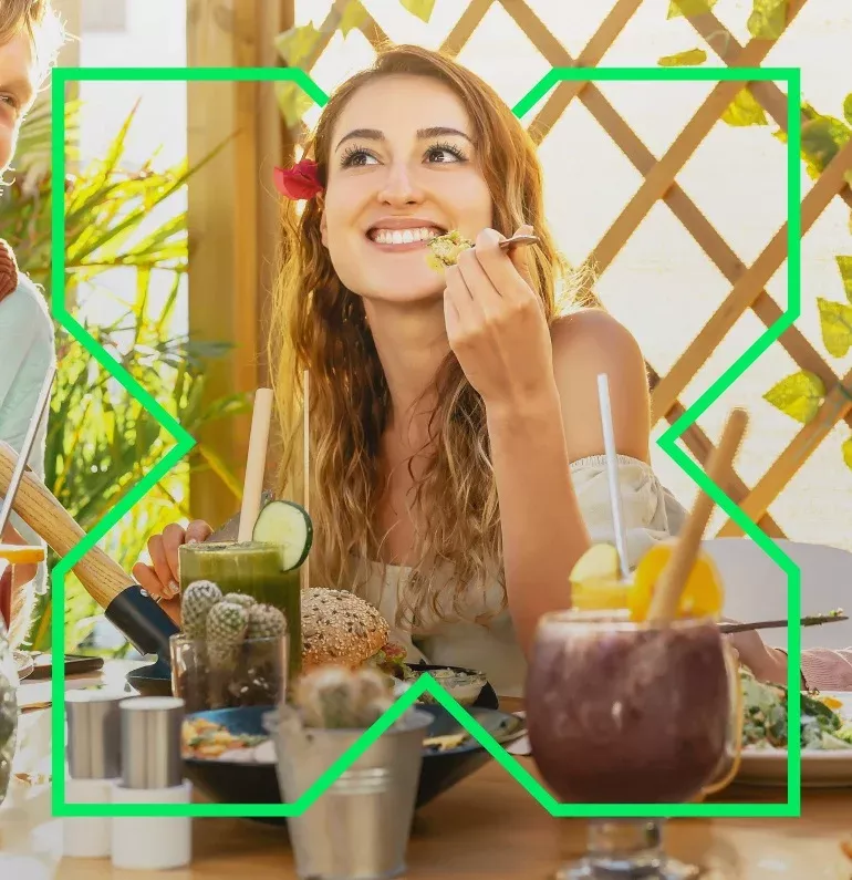 mujer comiendo con el ticket para restaurantes de pluxee 